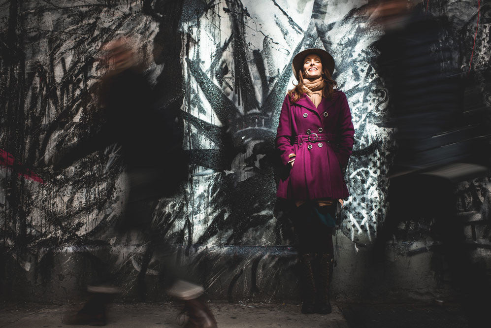 Woman standing against a wall with graffiti