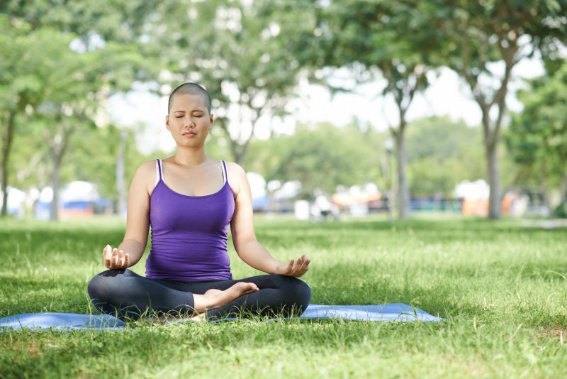 Woman sitting in meditation in a park