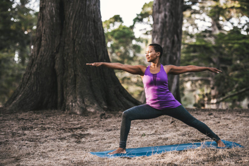 Woman in warrior pose in the forrest