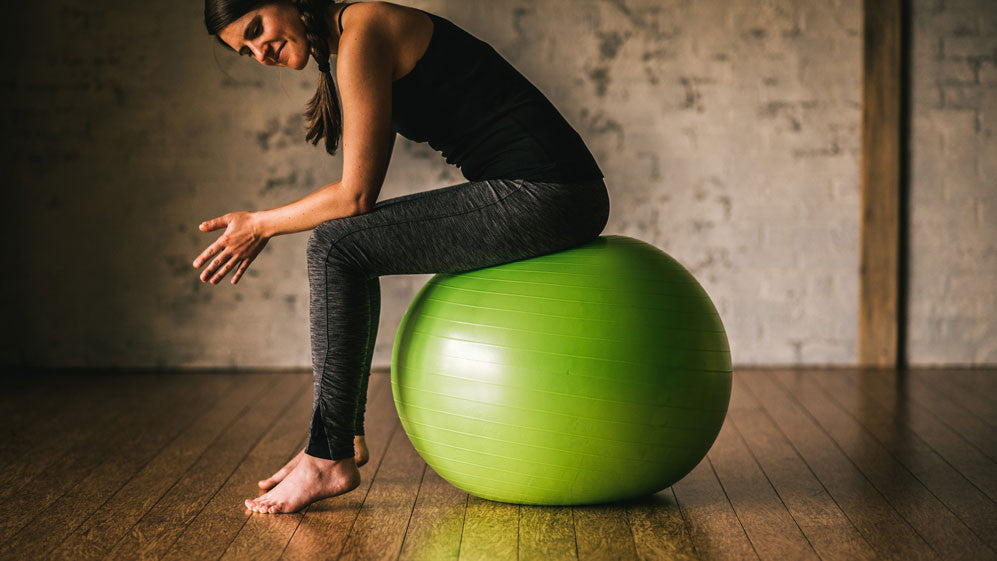 girl sitting on green balance ball
