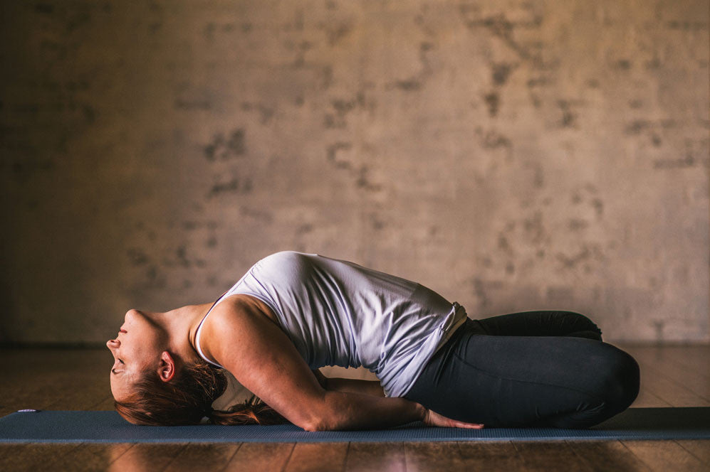 Woman on yoga mat in fish pose