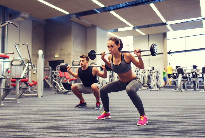Man and woman doing weighted squats for inner thigh exercise