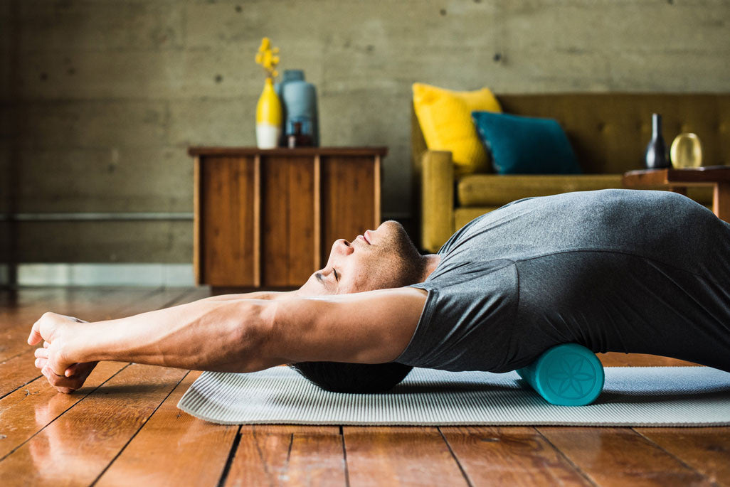 Man rolling shoulders on a foam roller