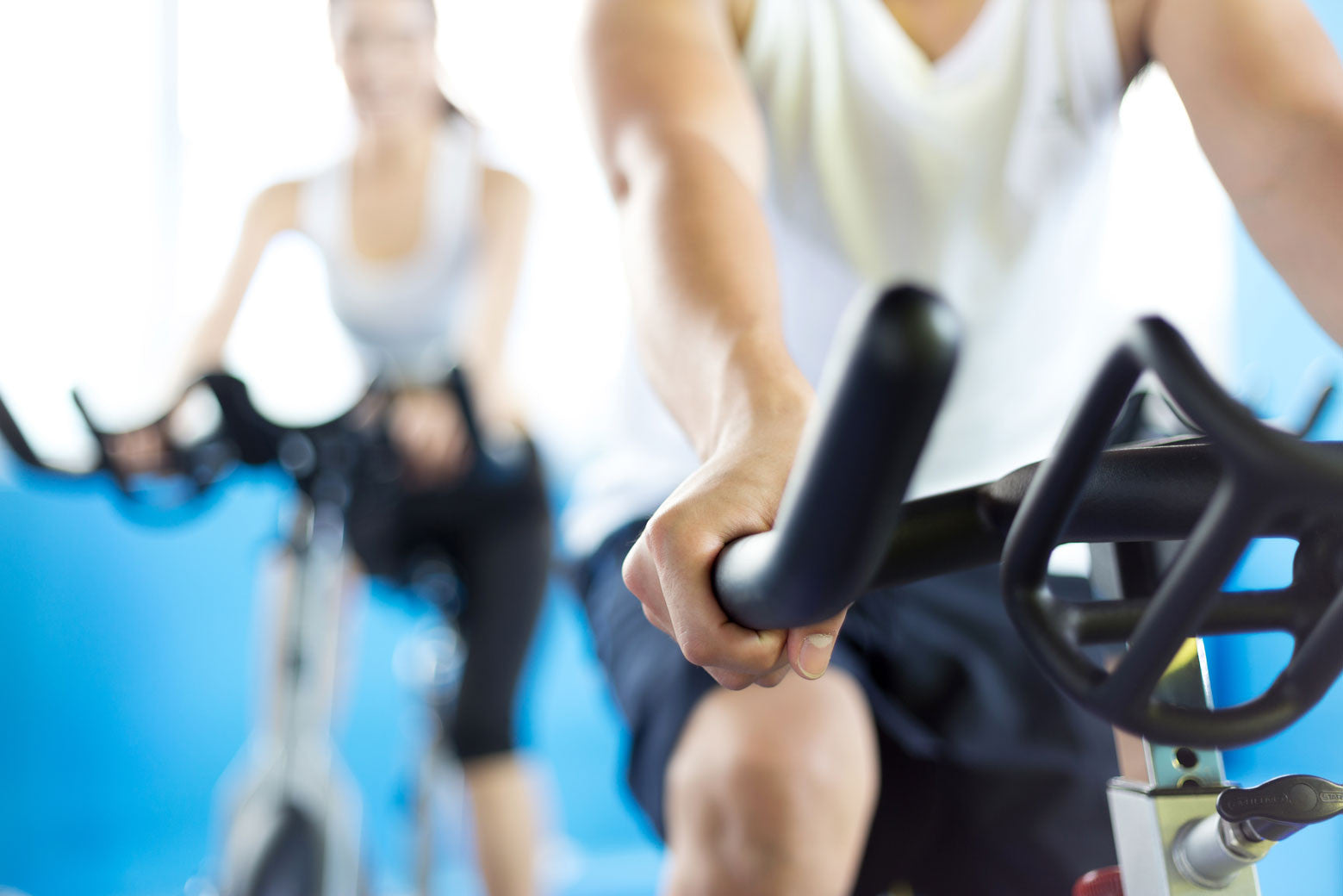 people on stationary exercise bikes in cycling class