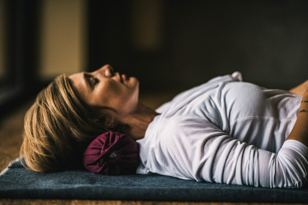 Woman laying down with bolster under her head
