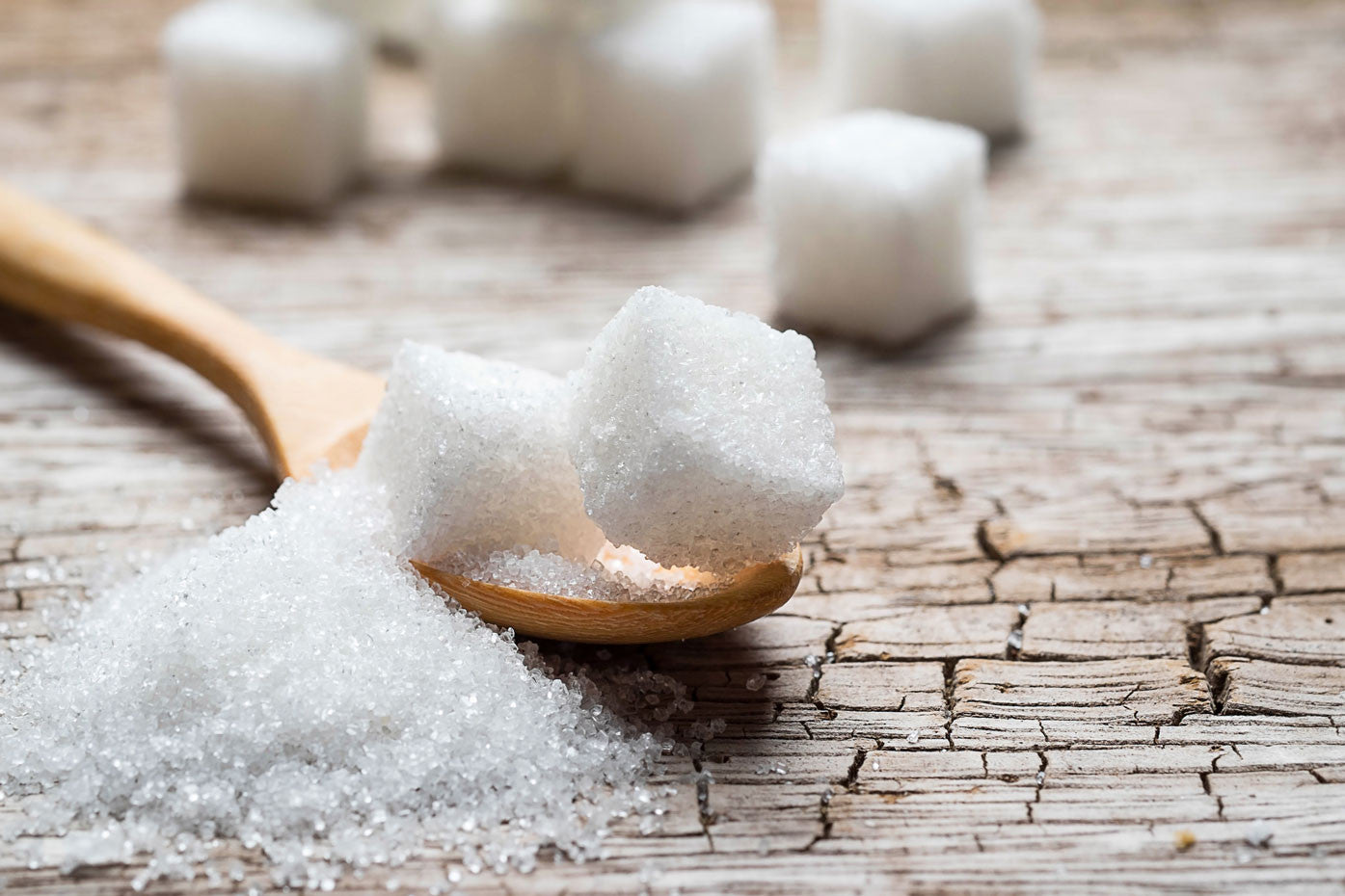 Cubes of sugar in a wooden spoon