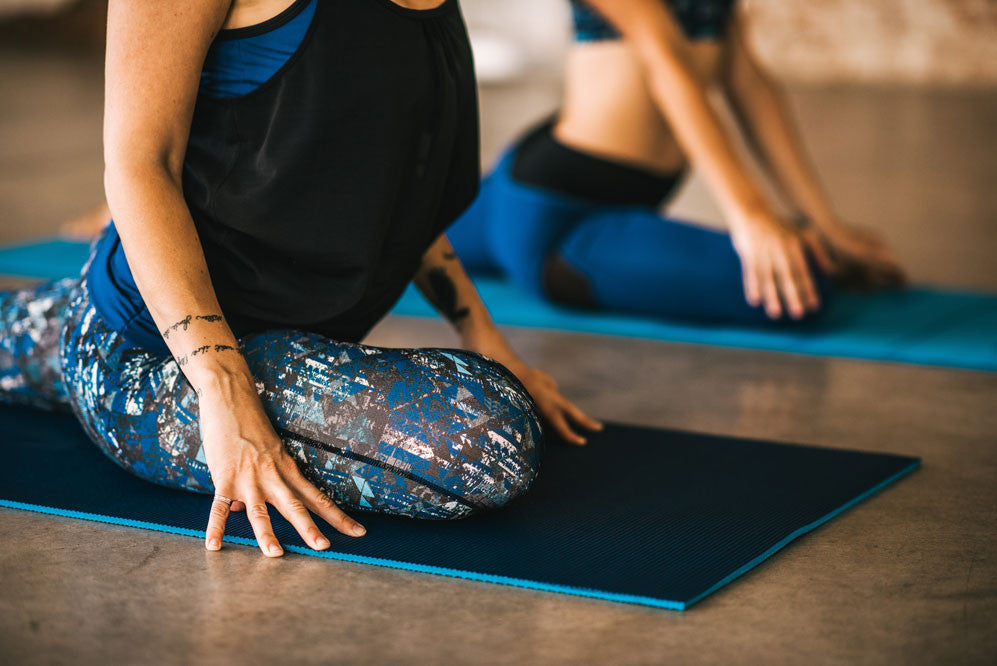 women doing pigeon pose in yoga class