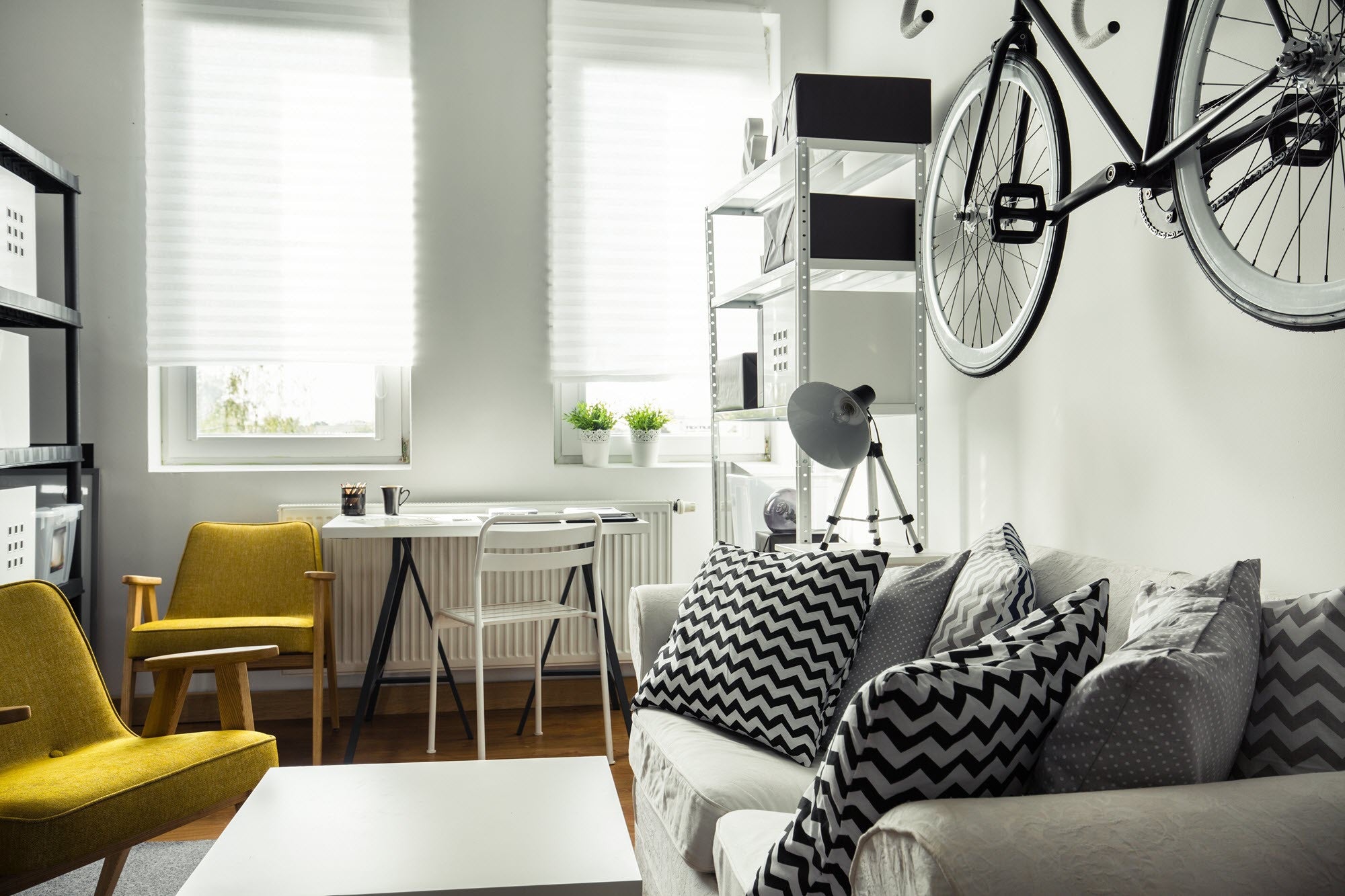 A modern clean living room with black white and yellow furniture
