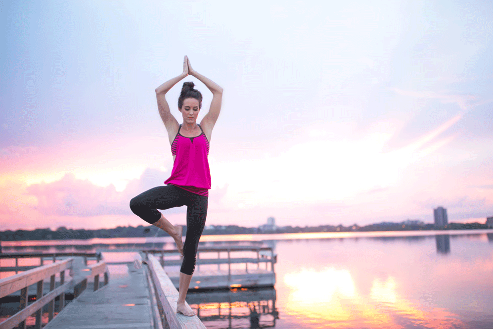 Woman in tree pose on a dock
