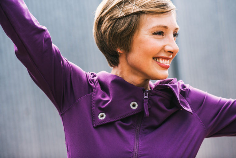 Woman in purple sweater smiles big