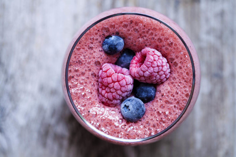 Pink smoothie with raspberries and blueberries on top