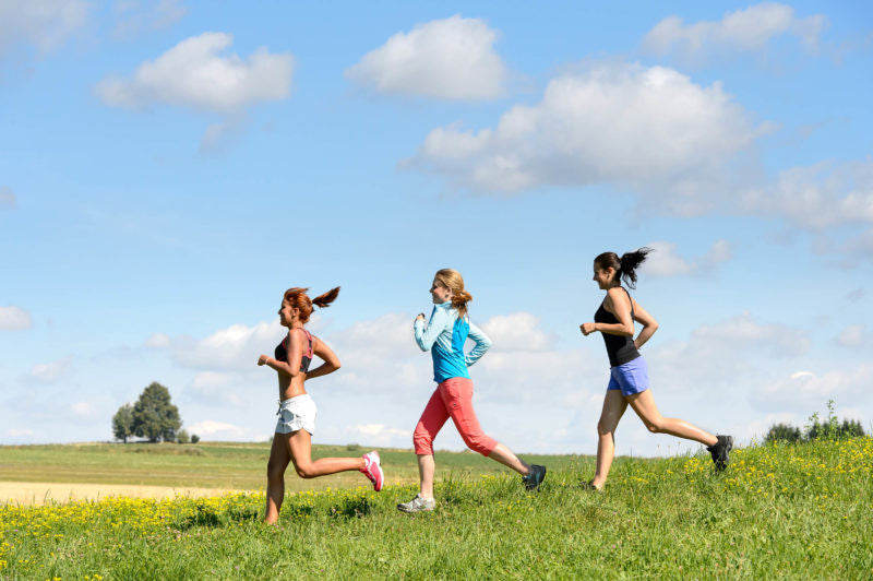 Three women running down a hill