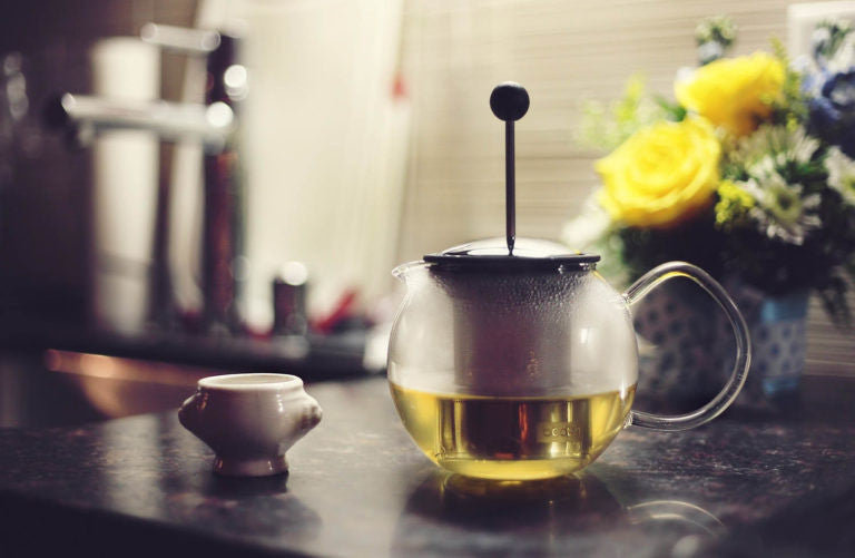 Tea kettle on table with yellow flowers