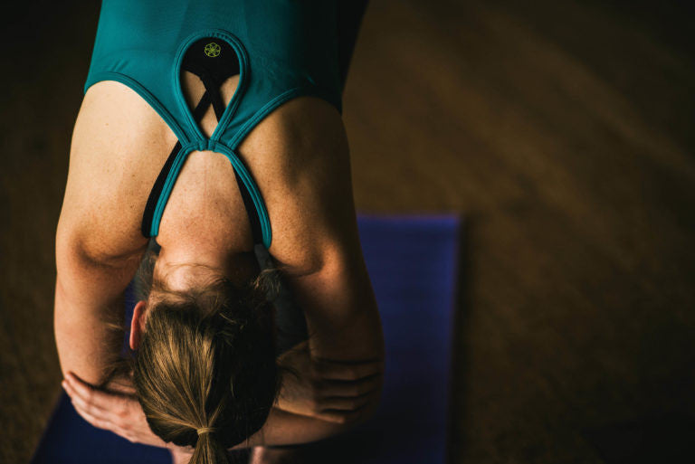 Woman in rag doll pose on yoga mat