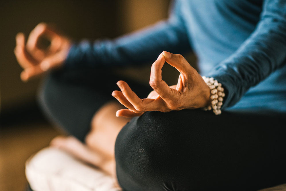 A women in a blue shirt in seated meditation