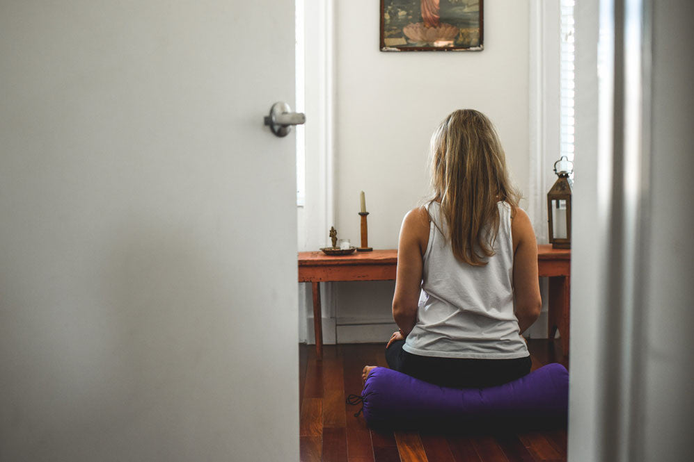 Woman meditating on cushion 