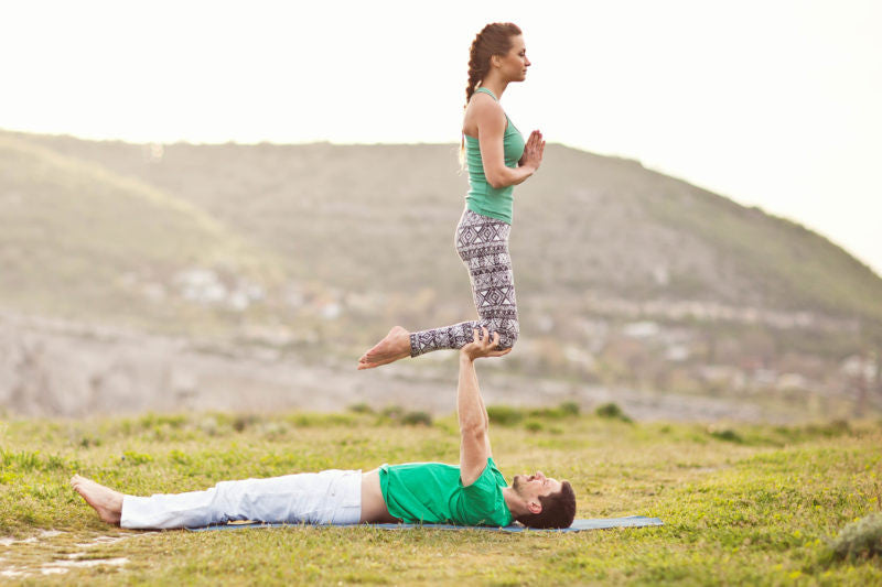 Couple practicing acro yoga outside
