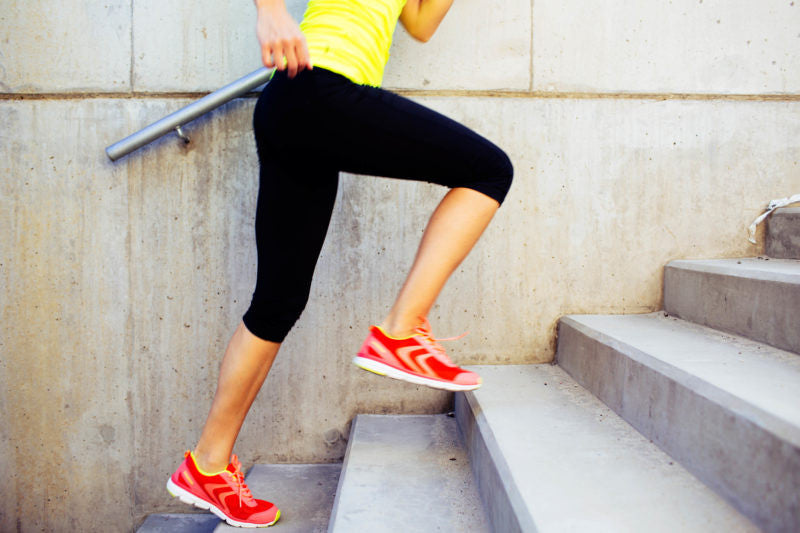 Woman running up the stairs with orange shoes