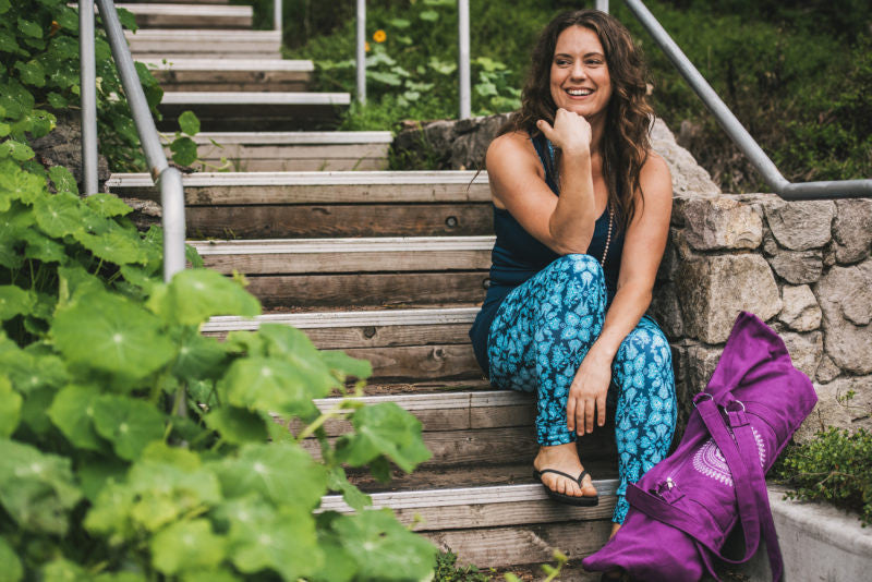 Woman sitting outside on stairs smiling 