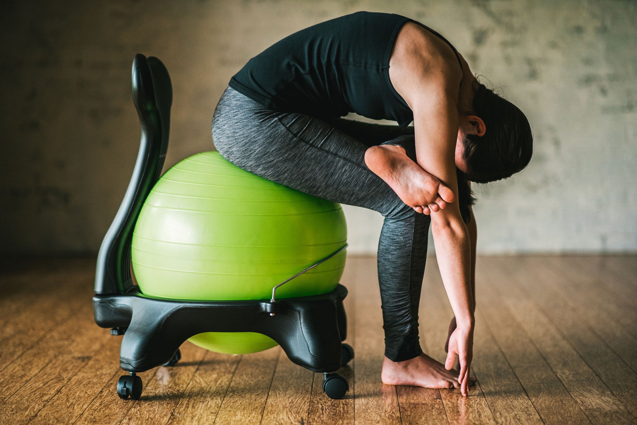 Woman folding at the waist on a Balance Ball Chair 