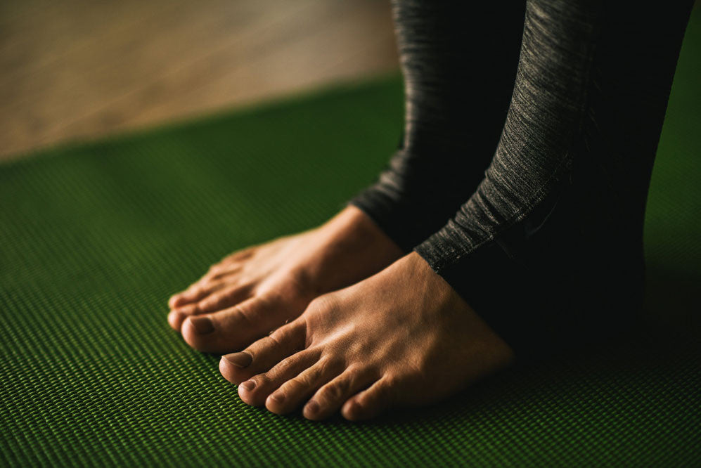 Woman barefoot on green yoga mat