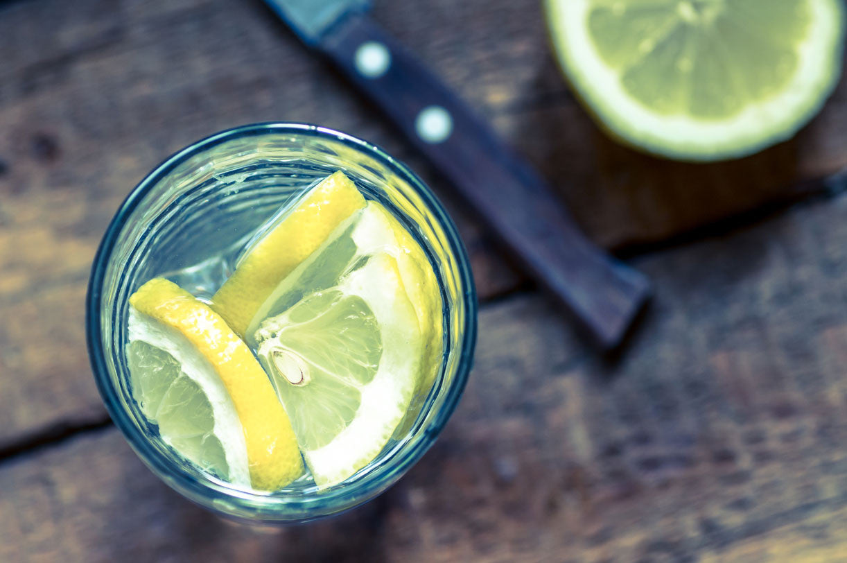 A glass of lemon water on a wood table