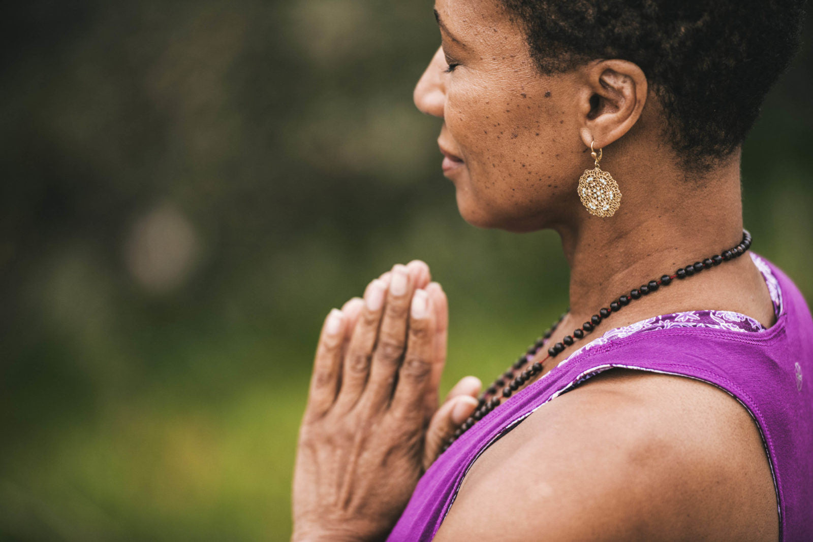 Woman standing in prayer pose with eyes closed