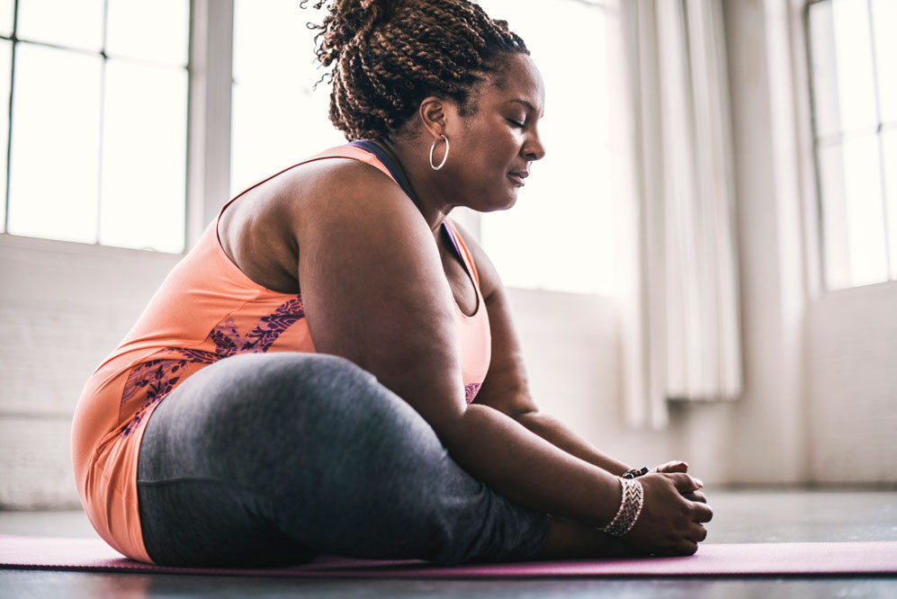 Woman sitting on ground in butterfly pose