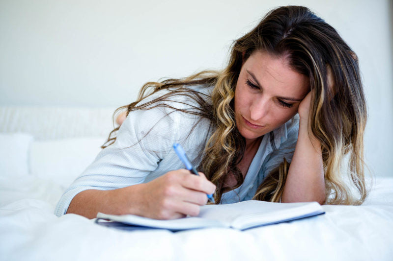 Woman writing in a journal 