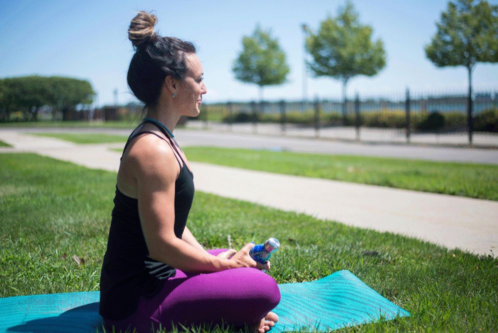 Girl with dark hair sits on blue yoga 