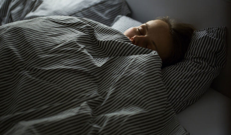 Woman in bed under covers 