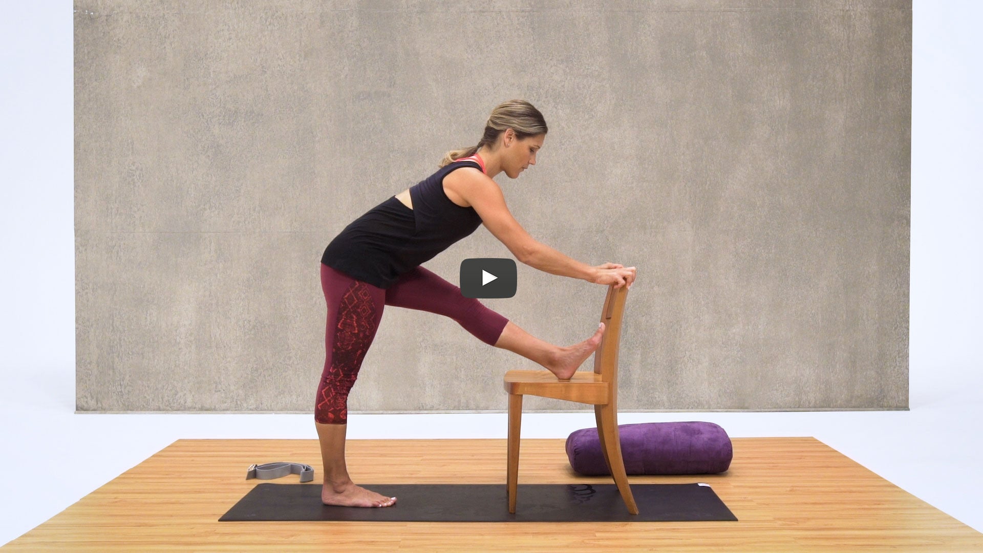 woman stretches leg on chair
