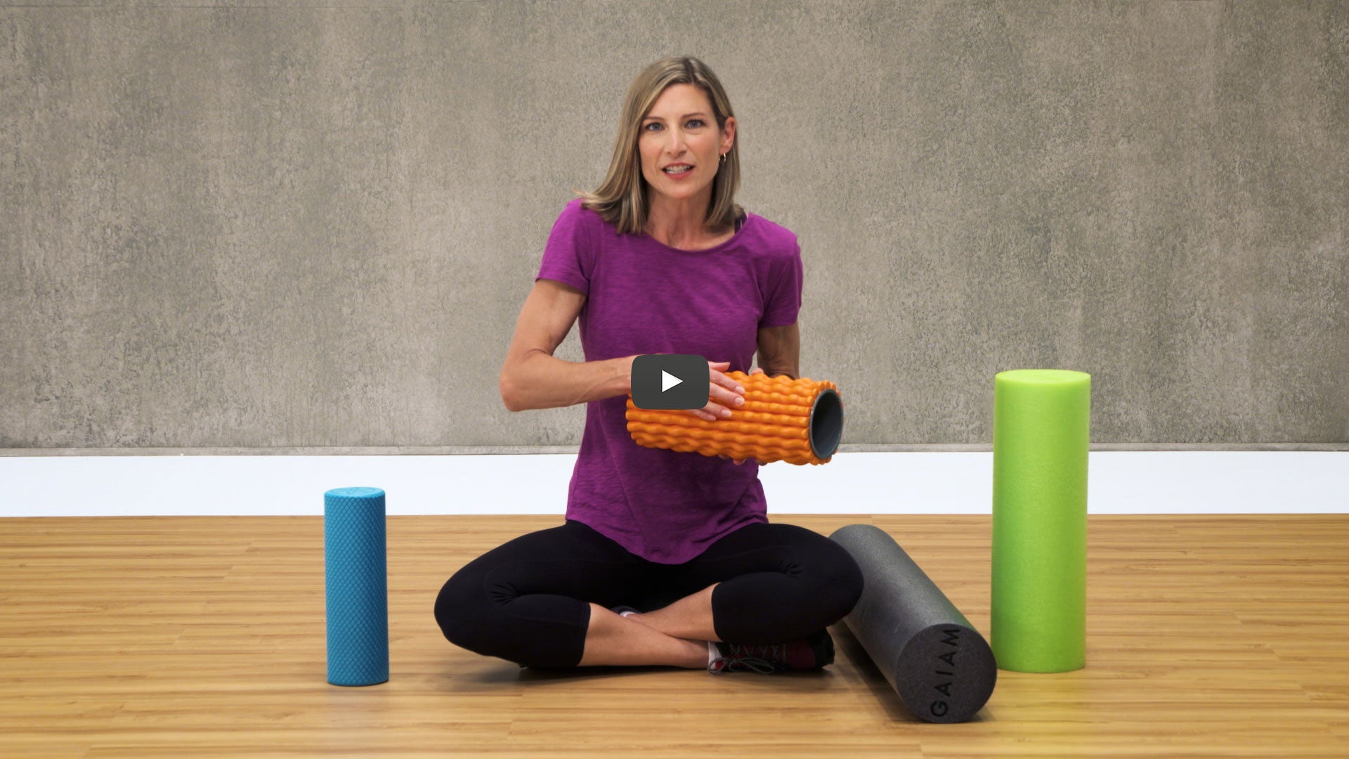 Woman holding an orange foam roller 