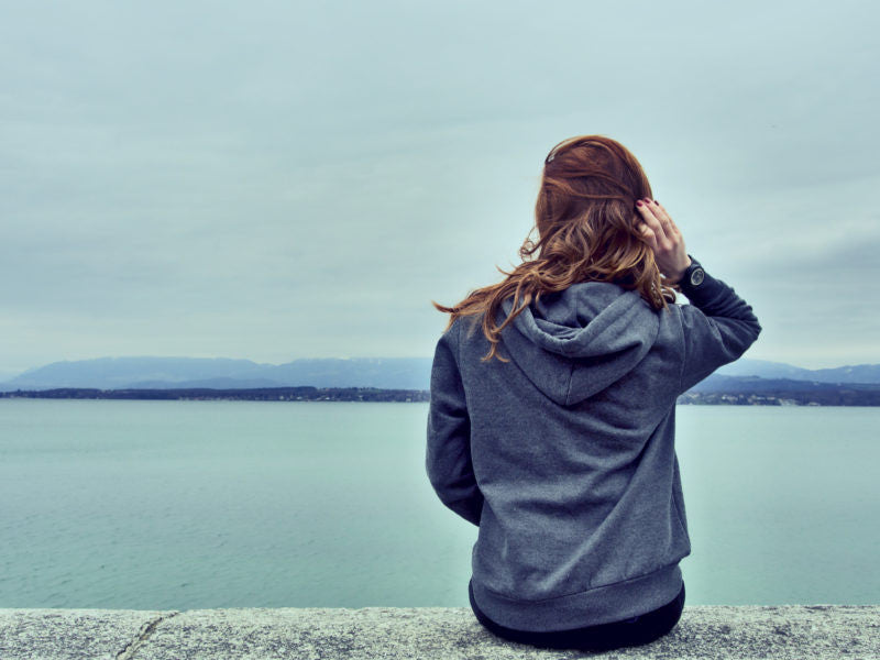 Woman sitting looking at the ocean