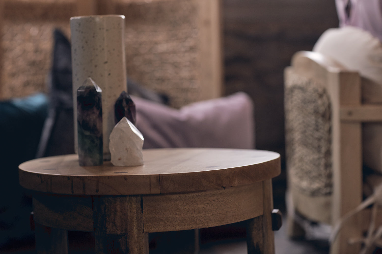 small wood side table has colorful crystals on top of it