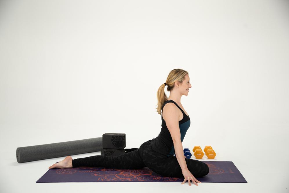 Blonde yoga girl does pigeon pose 