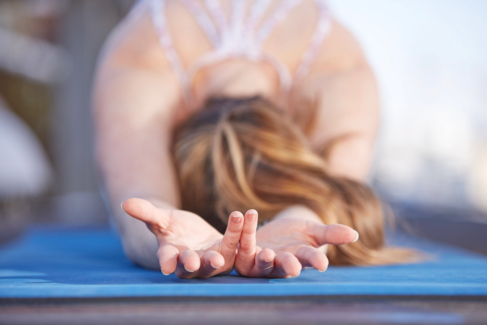 girl does childs pose with palms facing up