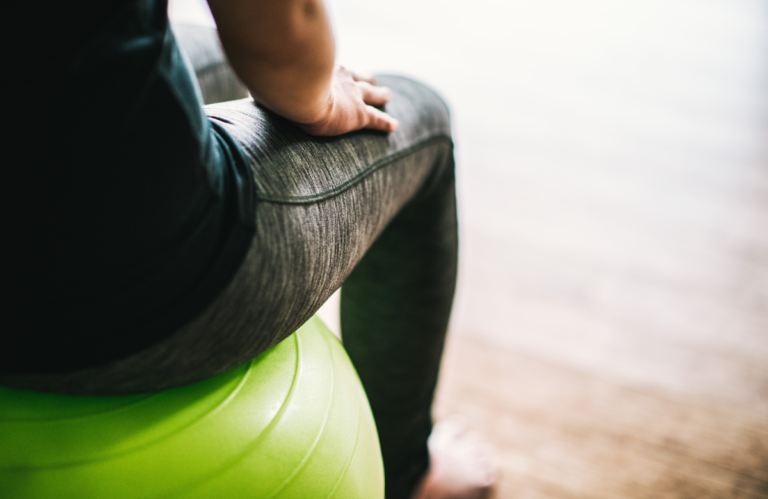 Person sitting on a green ball 