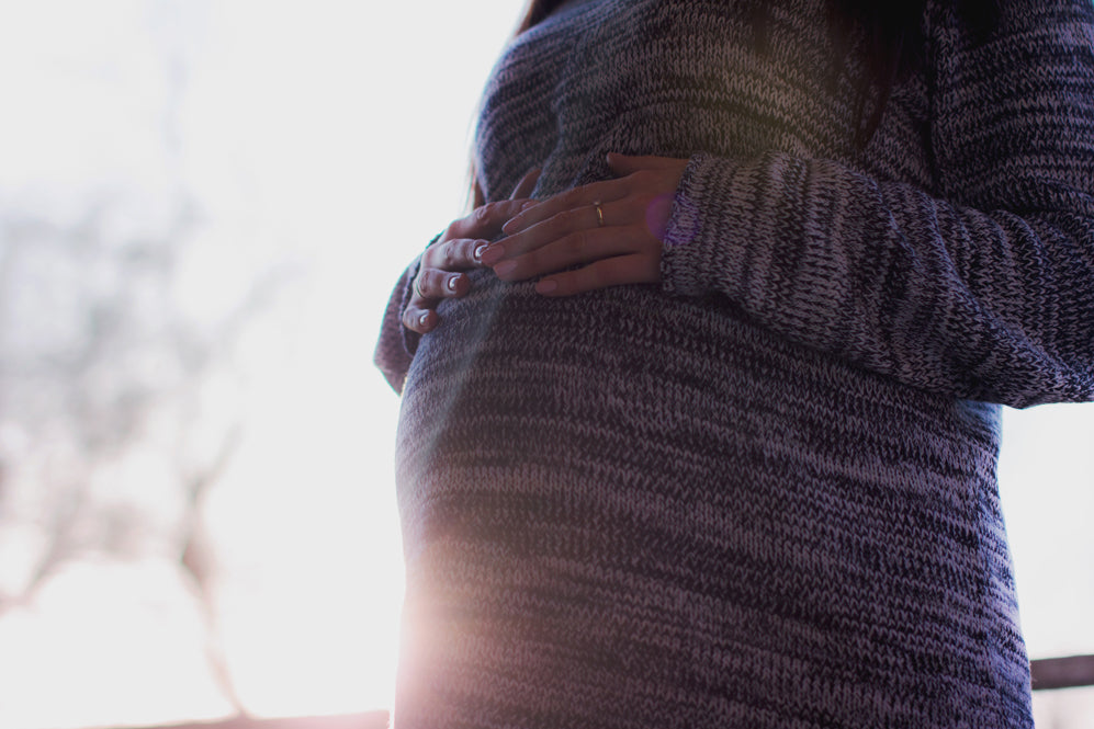 Pregnant woman with her hands on her belly