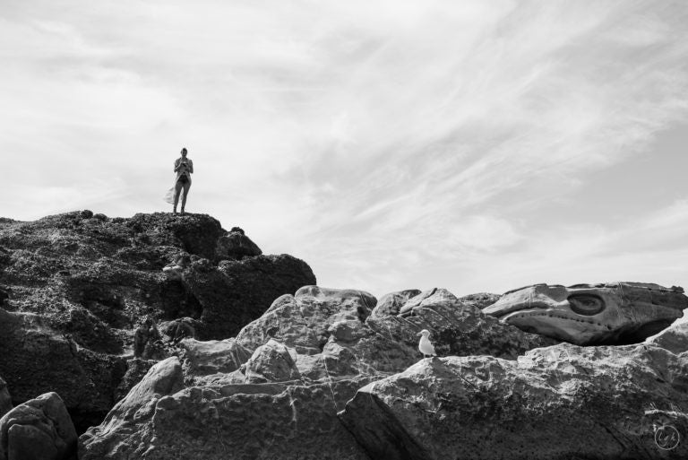 woman standing alone on large rock
