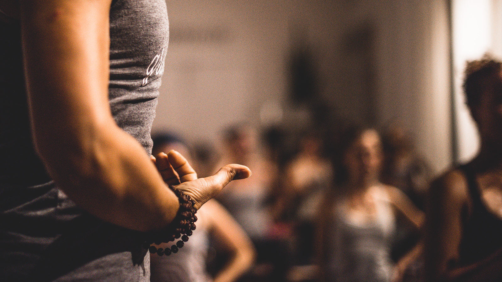 Yoga teacher points to her stomach in yoga class