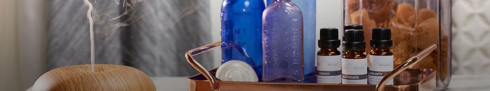 Aromatherapy diffuser, essential oils, and miscellaneous objects on a table.