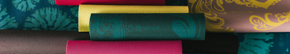 several colorful yoga mats rolled up