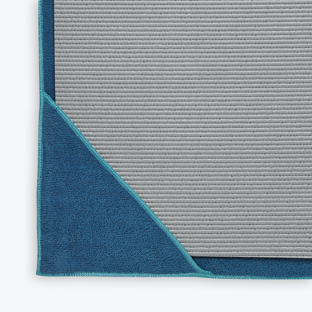 Blue Stay-Put Yoga Towel over edges of mat