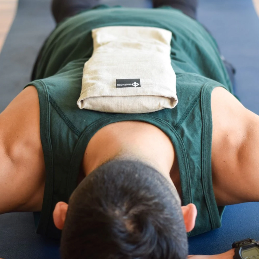 Person laying down with Hot + Cold Therapy pillow on back